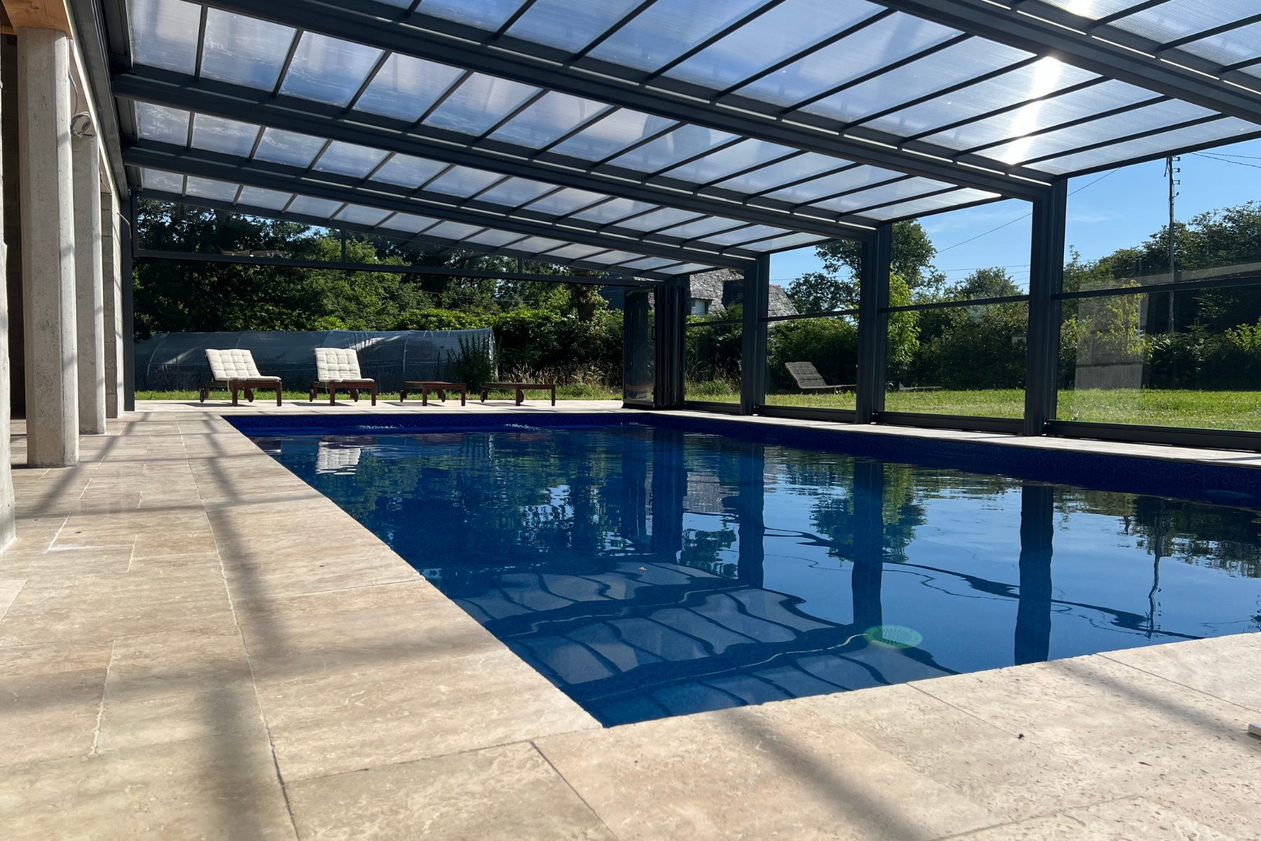 Gites in Brittany with Heated Swimming Pool in the Monts d'Arrée Heated Swimming Pool with Glass Enclosure open at one end with Sun Loungers in Teak