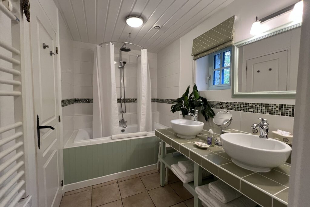 Luxury bathroom in Hayloft Gîte with double-ended bath and over-bath shower.