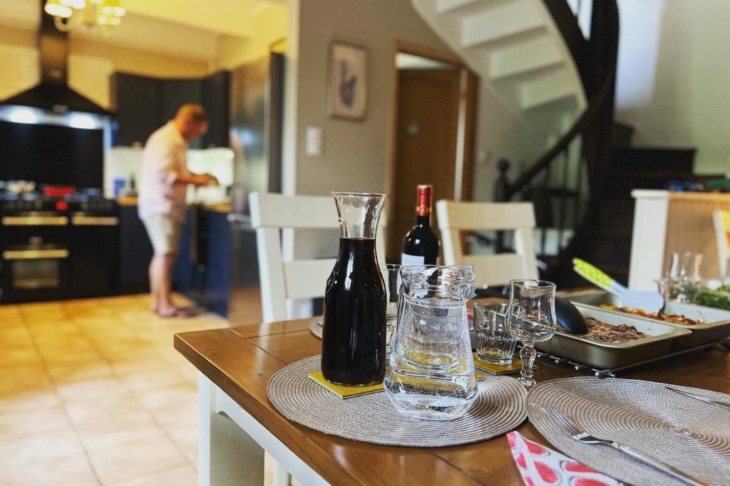 Man in kitchen making aperitifs whilst on a long weekend break in a brittany holiday cottage