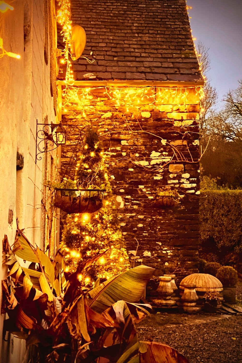 Traditional granite holiday cottages at Kergudon beautifully lit on a winter evening in rural Brittany