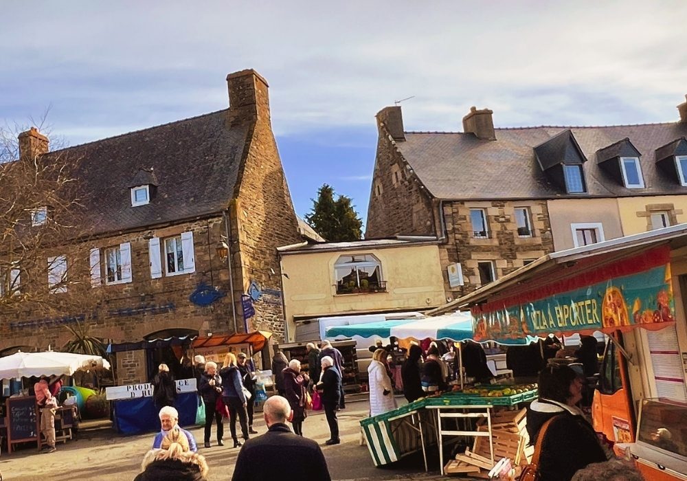 Visitors exploring a traditional weekly market during a winter holiday in Brittany